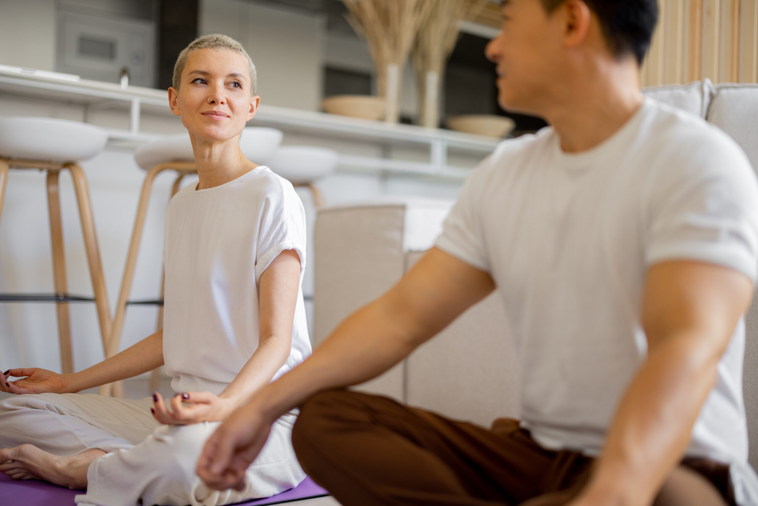 Couple practising yoga and meditating at home