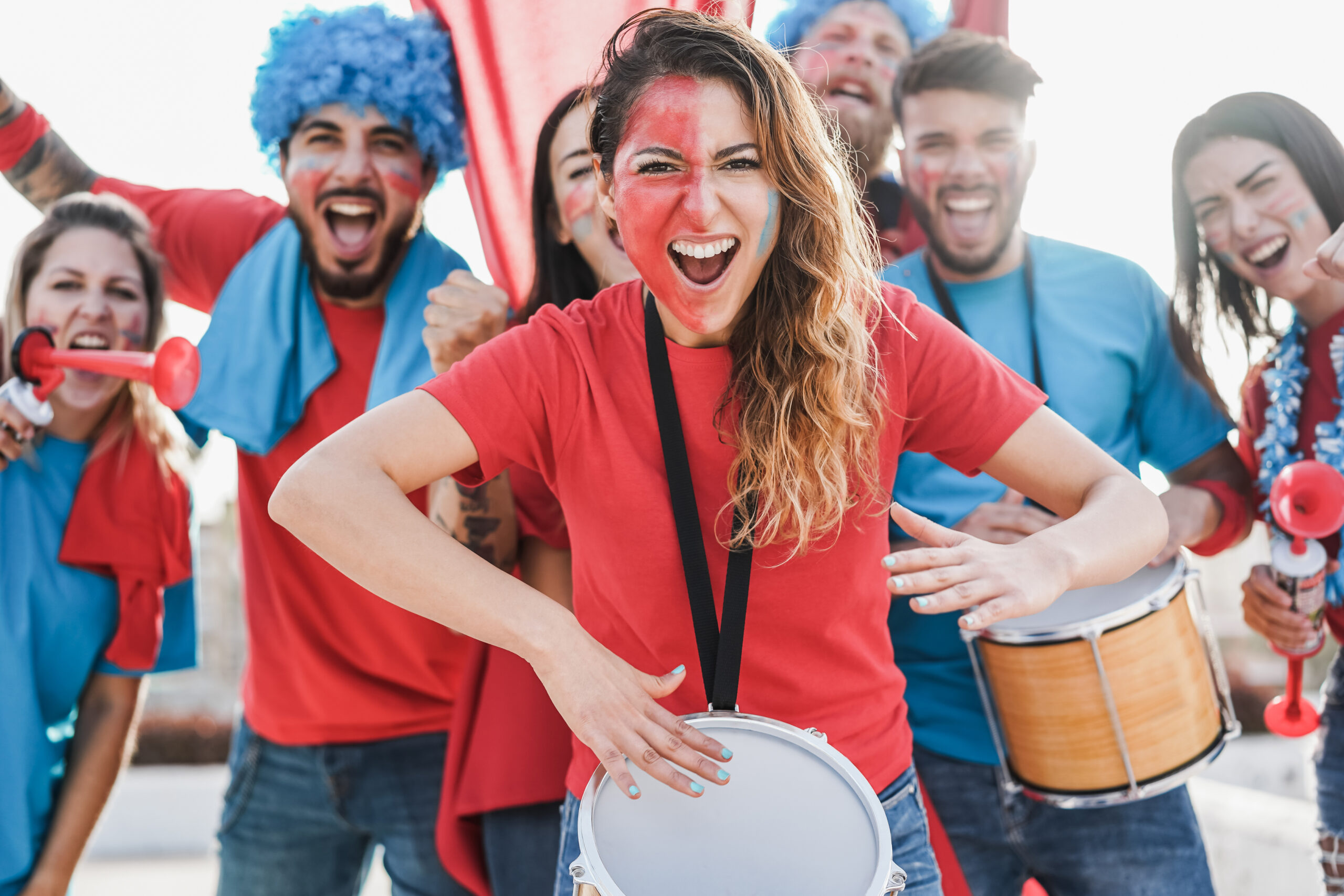 Crazy sport fans playing drums and screaming while supporting th